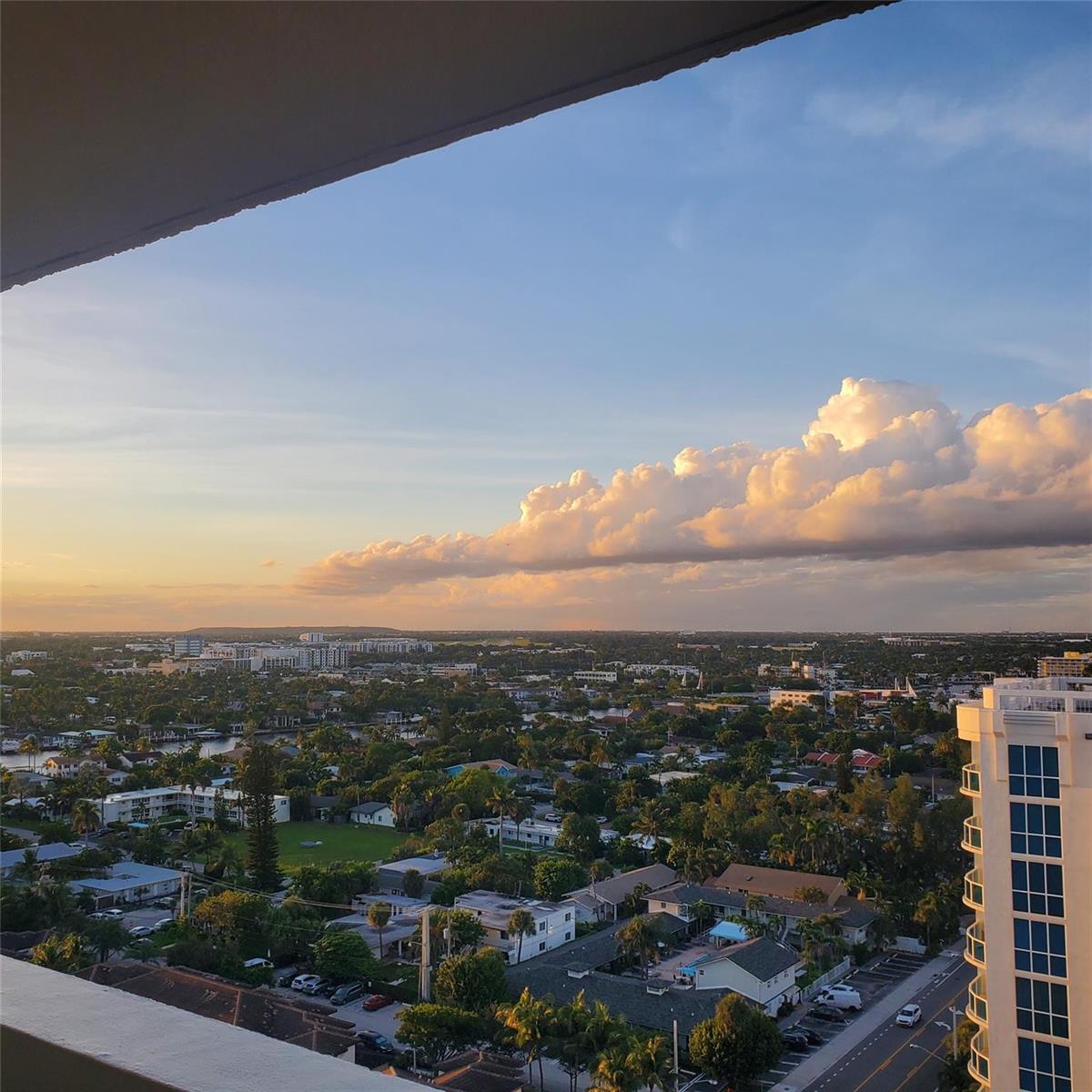 An elevated view of a suburban neighborhood with lush trees and a sunset sky — 1000 S Ocean Boulevard, Pompano Beach FL 33062, POMPANO BEACH, FL