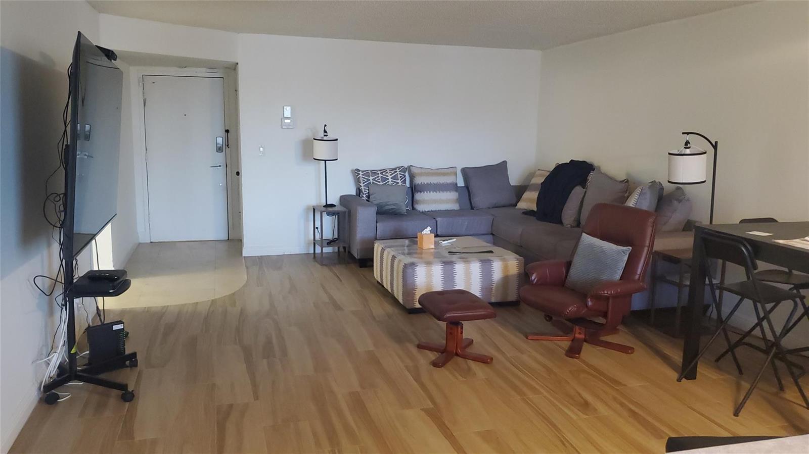 A living room features a sectional sofa, a leather armchair, and a television on a stand — 1000 S Ocean Boulevard, Pompano Beach FL 33062, POMPANO BEACH, FL