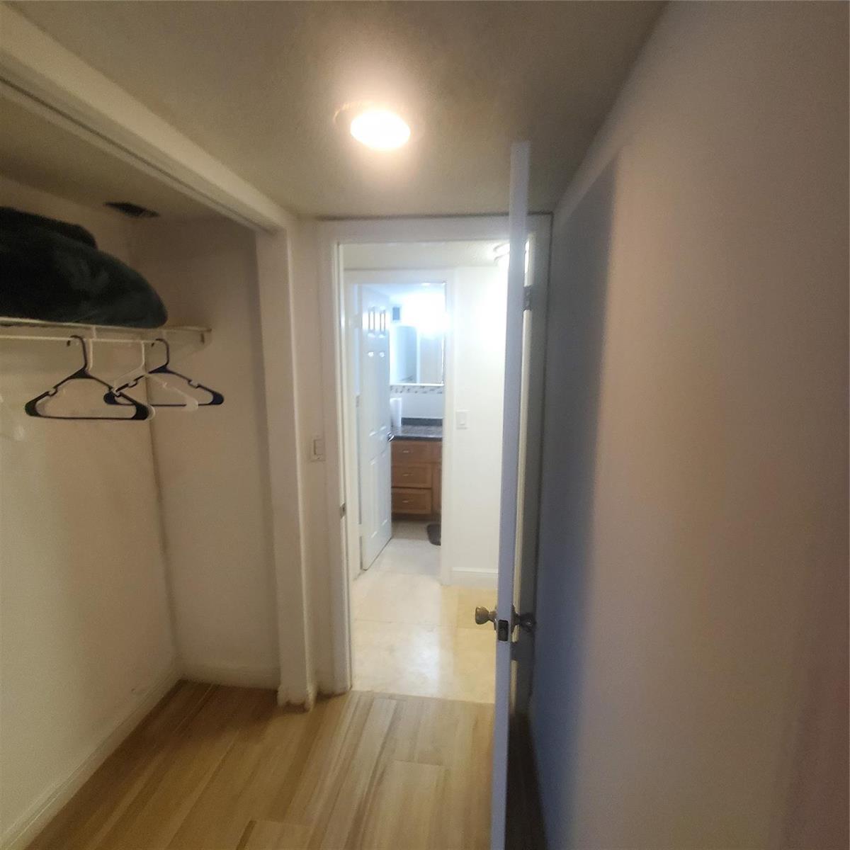 A view from a closet looking into a bathroom with a vanity and tile flooring — 1000 S Ocean Boulevard, Pompano Beach FL 33062, POMPANO BEACH, FL