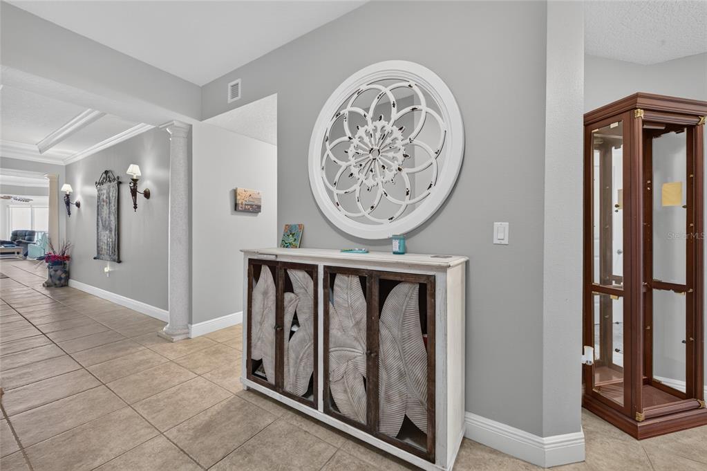 A hallway features tile flooring, a white cabinet with leaf-patterned doors, and a circular wall decoration — 2901 S ATLANTIC AVENUE UNIT 603, DAYTONA BEACH, FL