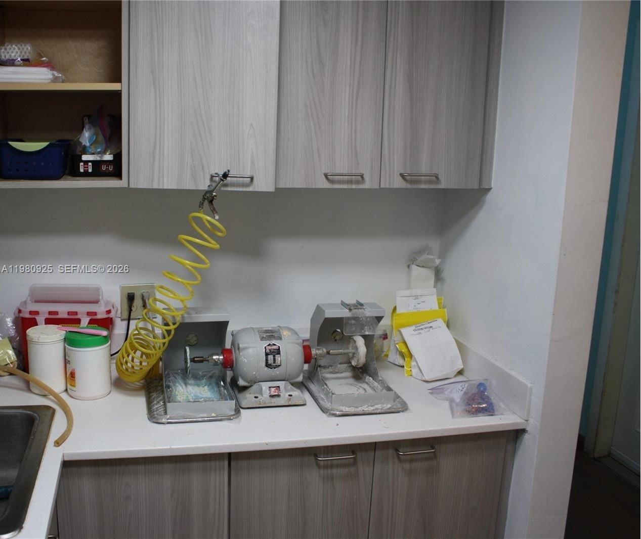 A dental laboratory workspace features a countertop with a polishing lathe and cabinets above — 1235 Alton Rd, Miami Beach FL 33139, MIAMI BEACH, FL