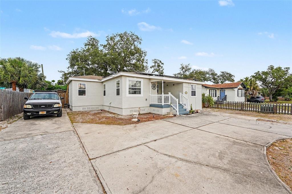 A single-story house with a concrete driveway, a front porch, and a parked pickup truck — 1464 DRUID ROAD E, CLEARWATER, FL
