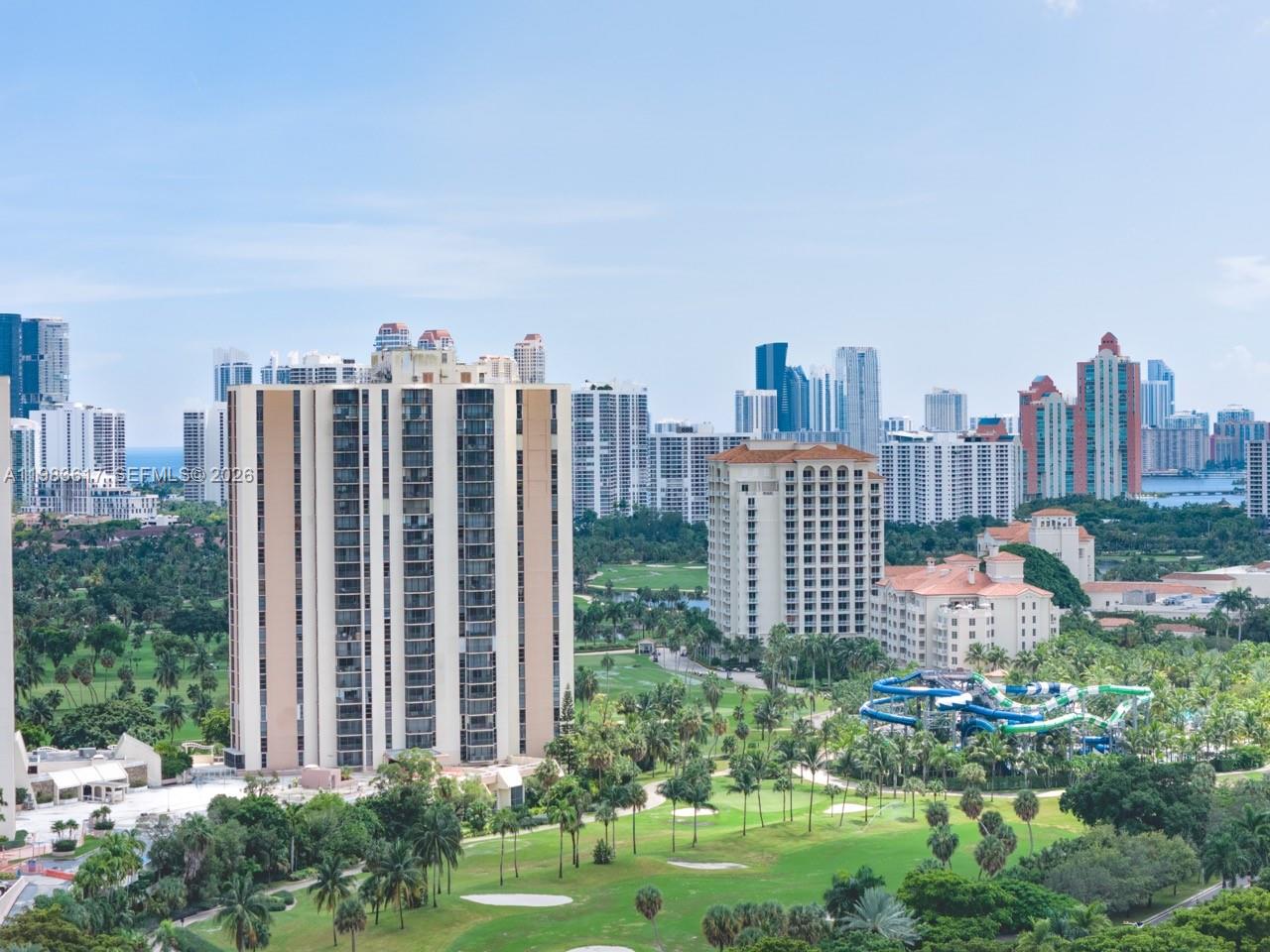 An elevated view of a golf course, water park, and surrounding high-rise apartment buildings — 20335 W Country Club Dr # 1208, Aventura FL 33180, AVENTURA, FL