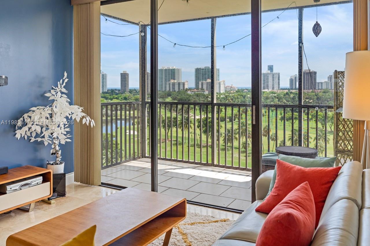 A living room with a balcony overlooking a golf course and city skyline — 20335 W Country Club Dr # 1208, Aventura FL 33180, AVENTURA, FL