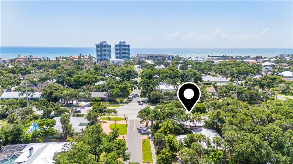 An aerial view shows a residential neighborhood with lush trees near the ocean — VERO BEACH, FL