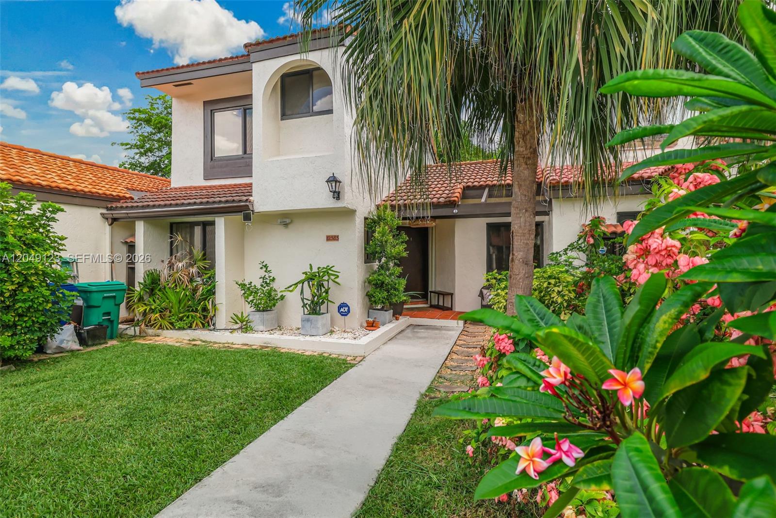 A two-story stucco house features a tiled roof, a concrete walkway, and lush landscaping — 12383 SW 94th Ter, Miami FL 33186, MIAMI, FL