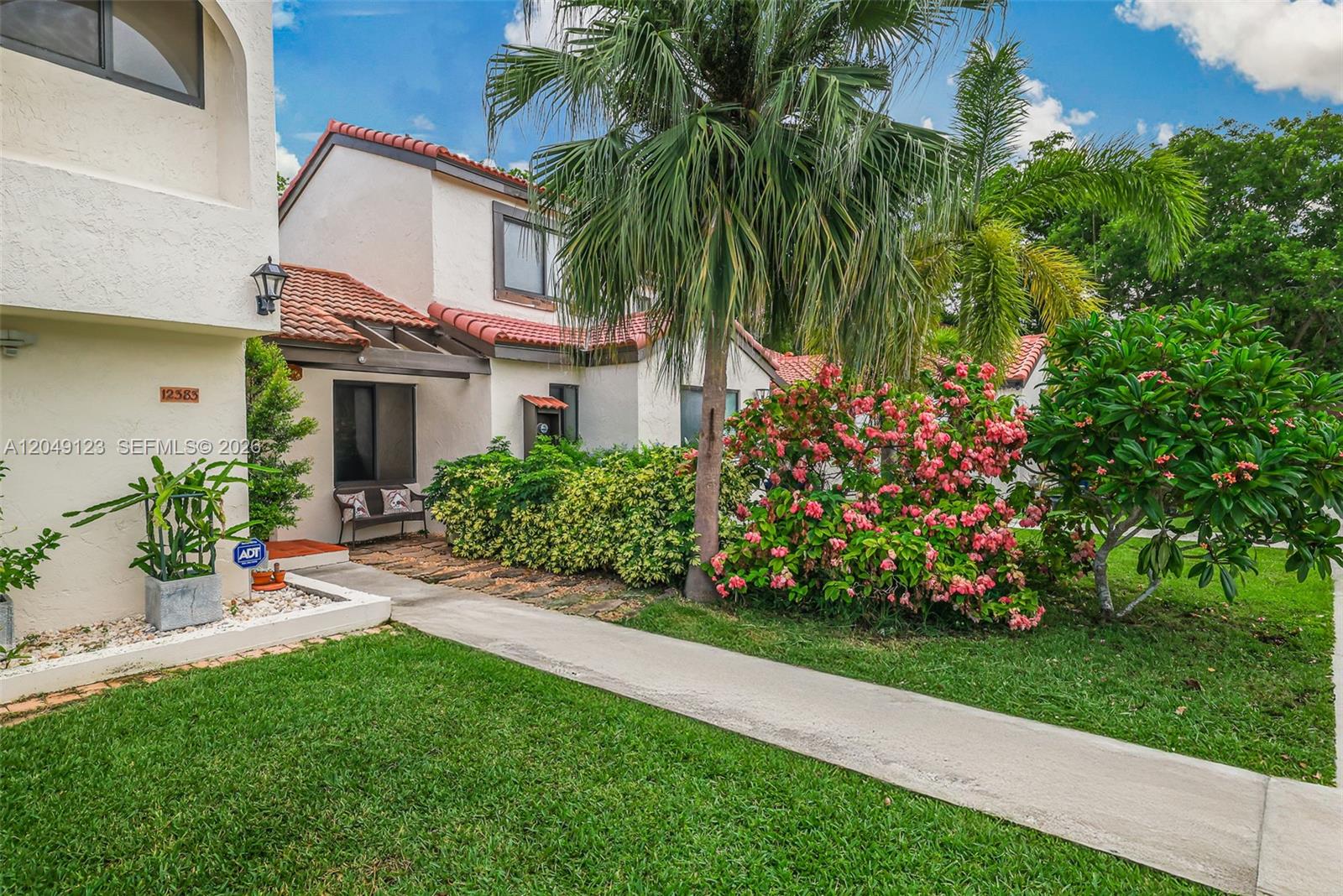 A two-story stucco townhouse features a tiled roof, a palm tree, and a landscaped yard — 12383 SW 94th Ter, Miami FL 33186, MIAMI, FL
