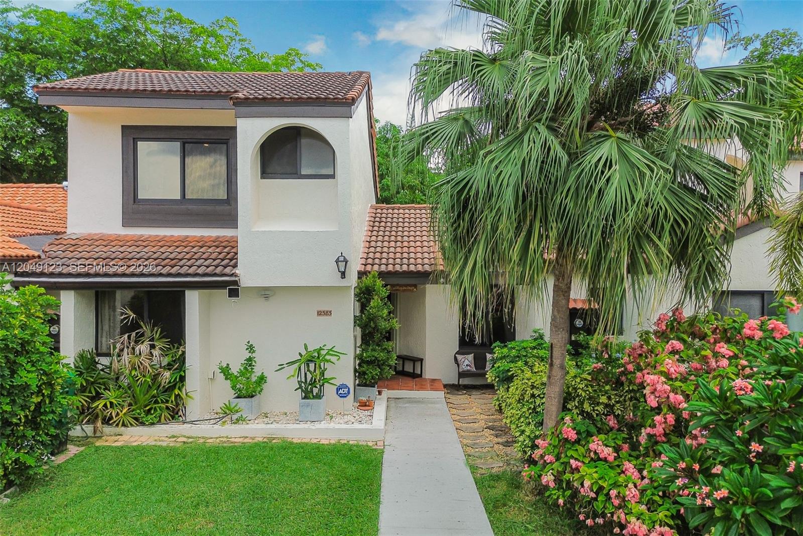 A two-story stucco house with a tiled roof, palm tree, and front garden walkway — 12383 SW 94th Ter, Miami FL 33186, MIAMI, FL