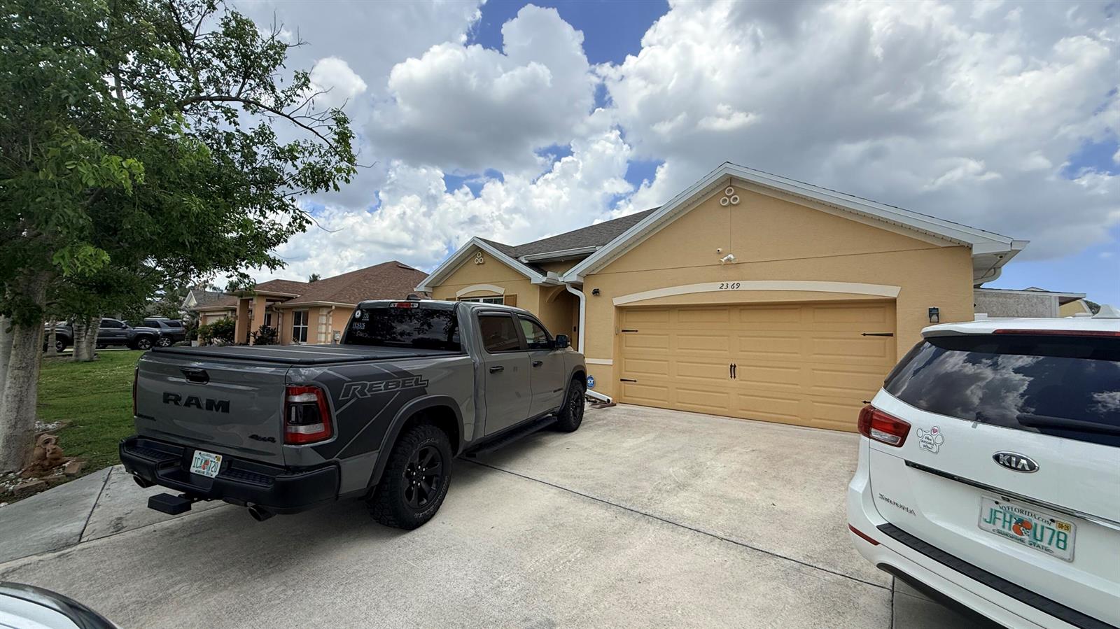 A gray pickup truck and a white SUV are parked in the driveway of a house — 2369 SW Barber Lane, Port St. Lucie FL 34984, PORT ST. LUCIE, FL