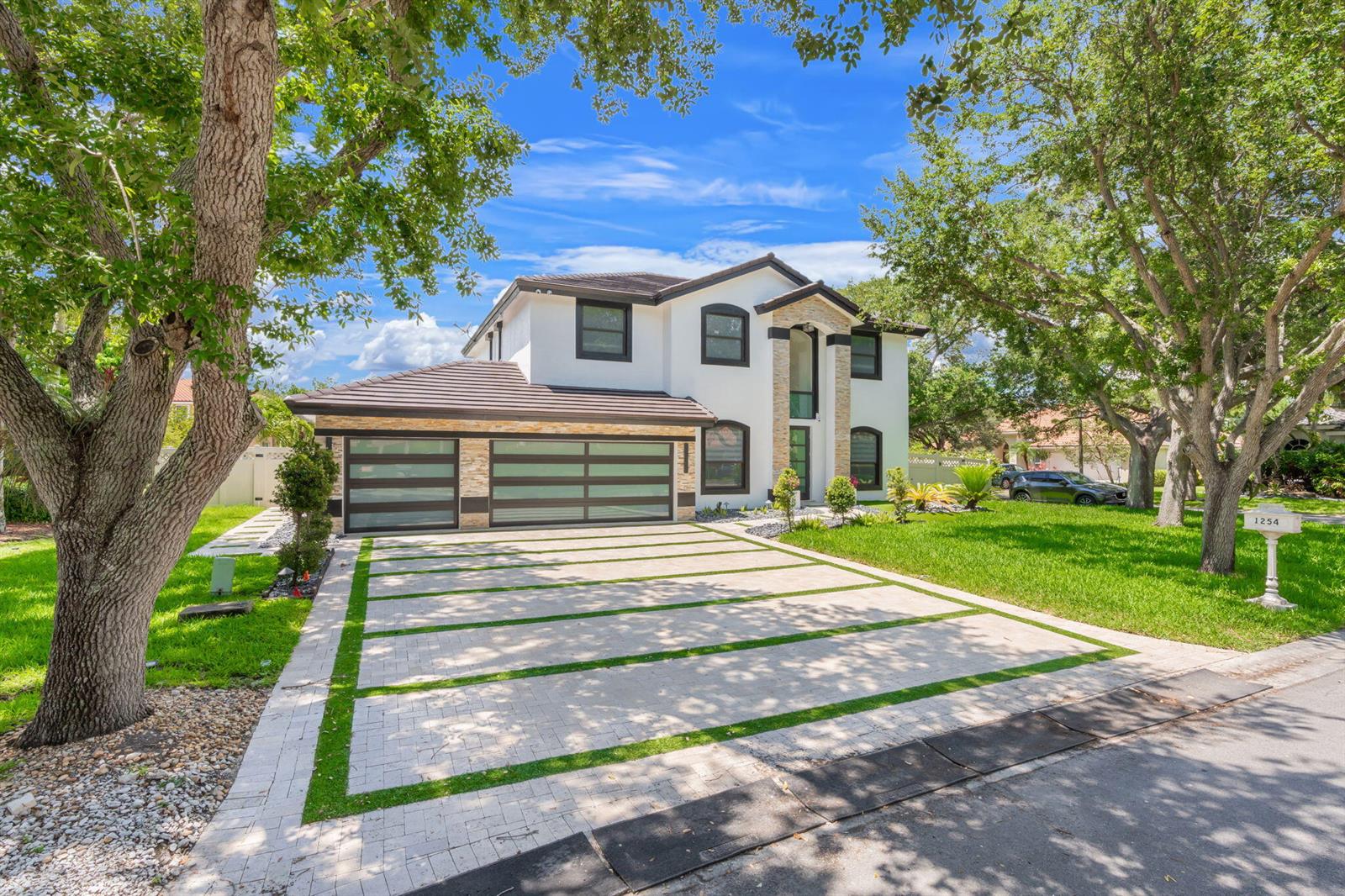 A two-story house with a modern garage and a paved driveway featuring grass strips — 1254 NW 102nd Way, Coral Springs FL 33071, CORAL SPRINGS, FL