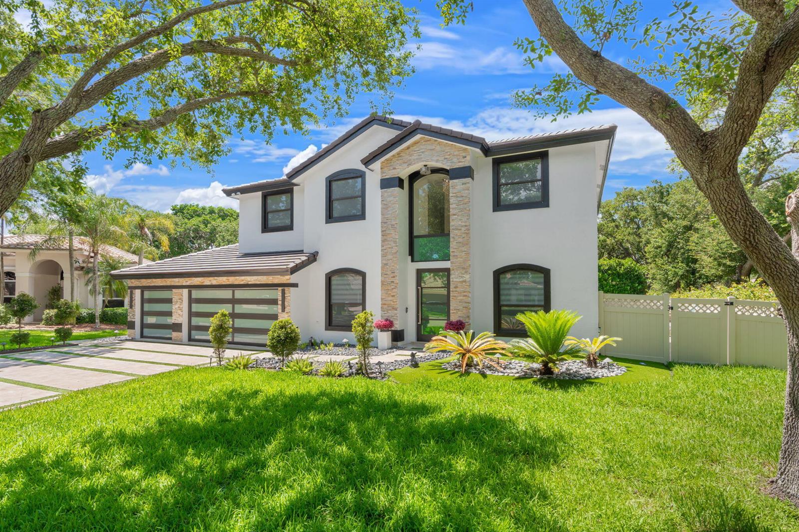 A two-story white house with a stone facade, dark window frames, and a garage — 1254 NW 102nd Way, Coral Springs FL 33071, CORAL SPRINGS, FL