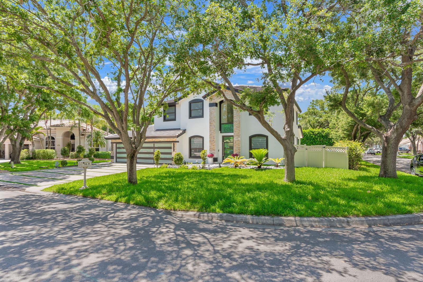 A two-story white house with a stone facade, dark trim, and a multi-car garage — 1254 NW 102nd Way, Coral Springs FL 33071, CORAL SPRINGS, FL