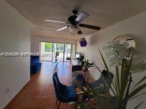 A dining area with blue chairs leads to a living room with tile floors — 20 NW 87th Ave # A214, Miami FL 33172, MIAMI, FL
