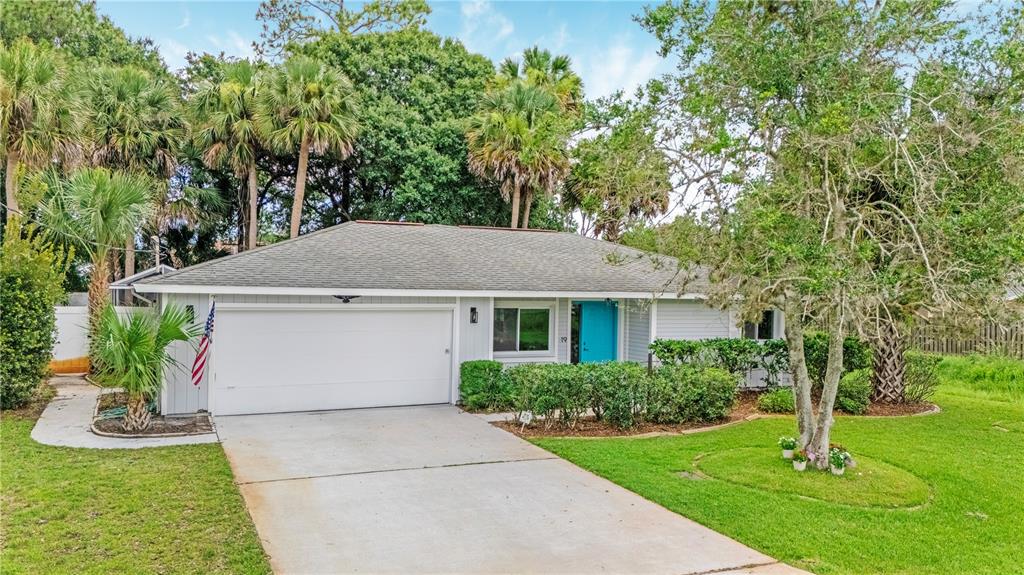 A single-story house with light blue siding, a white garage door, and a bright blue door — 19 BANNER LANE, PALM COAST, FL