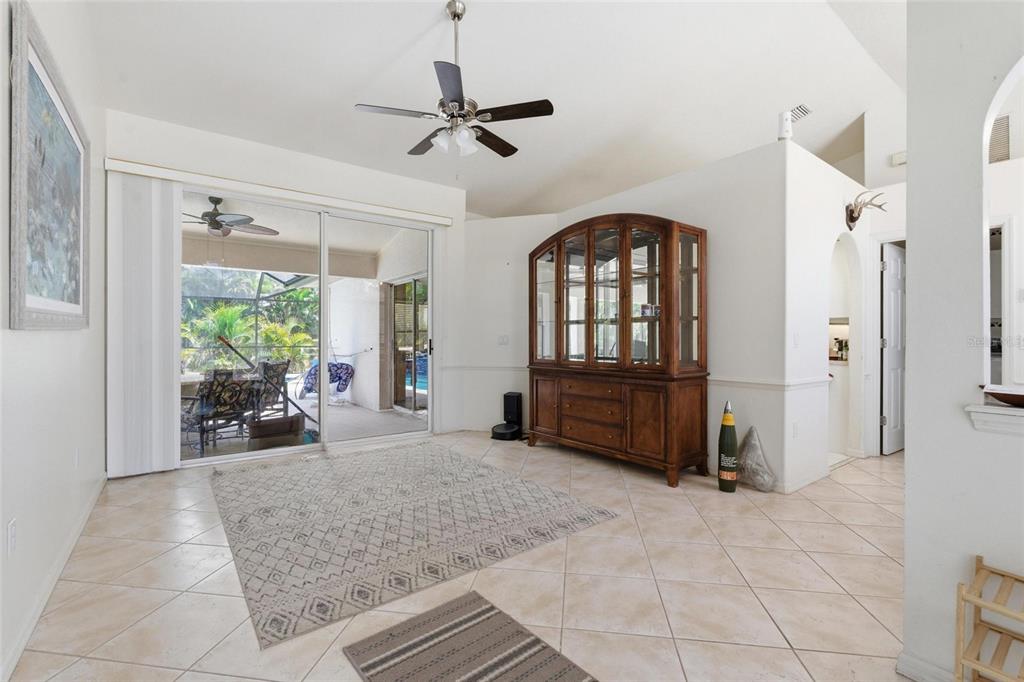 A dining room features tile floors, a large wooden hutch, and sliding glass doors — 257 BROADMOOR LANE, ROTONDA WEST, FL