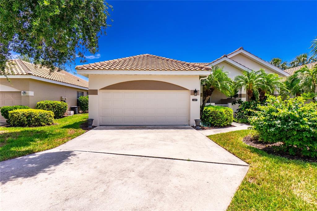 A single-story house with a beige stucco exterior, a tiled roof, and a two-car garage — 15237 KNOTS LANDING UNIT 6A, FORT MYERS, FL