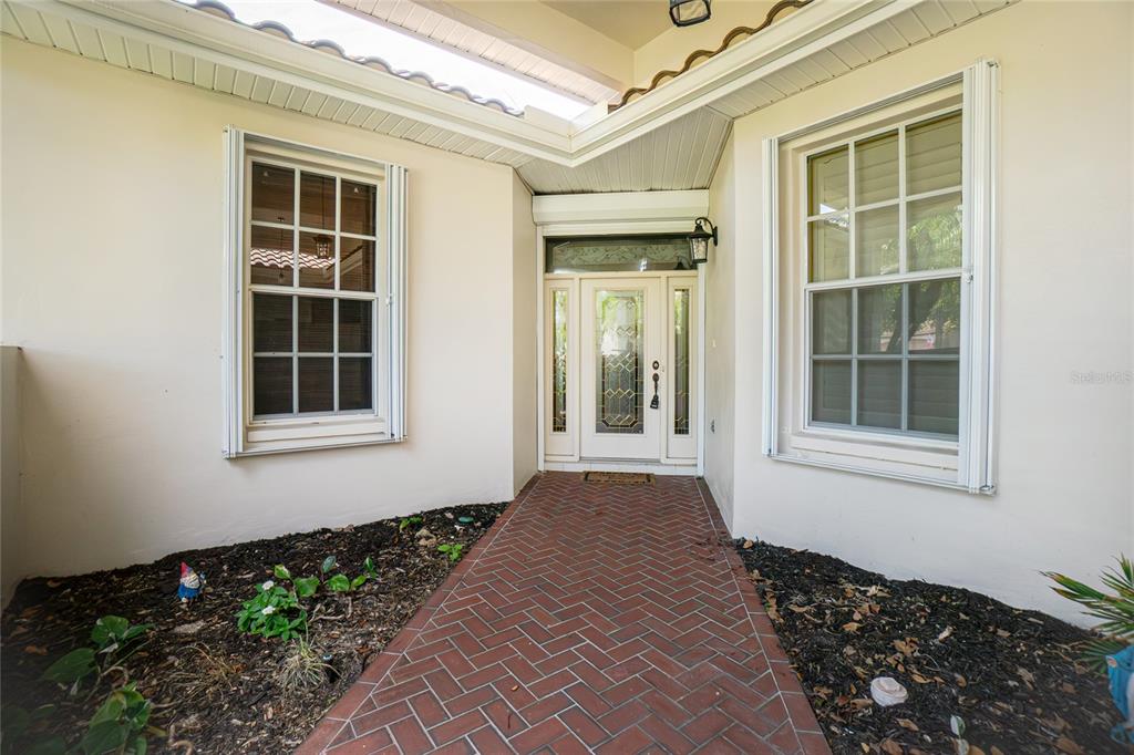 A brick walkway leads to a front door with sidelights between two windows — 15237 KNOTS LANDING UNIT 6A, FORT MYERS, FL