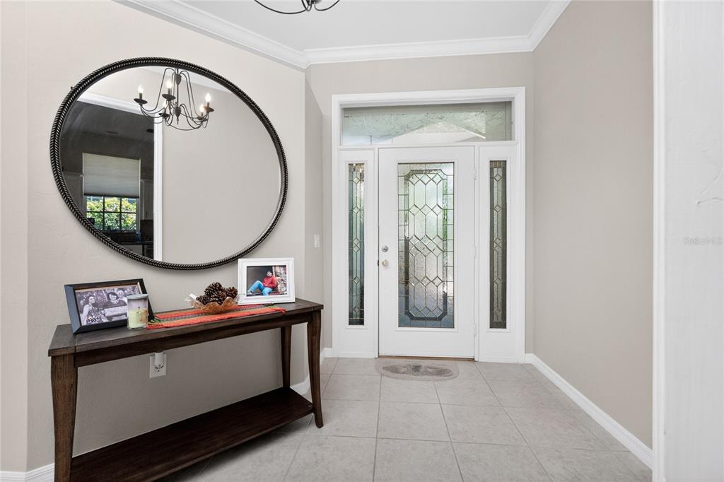 A foyer features a console table, a large round mirror, and a glass-paneled front door — 15237 KNOTS LANDING UNIT 6A, FORT MYERS, FL