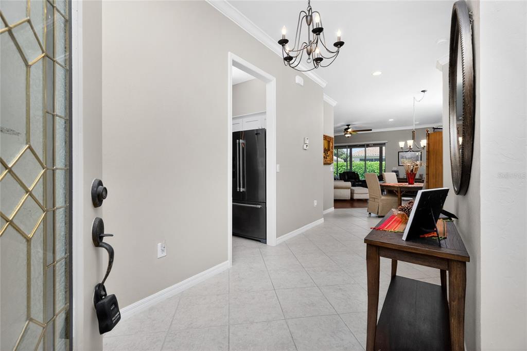 A view from an entryway into a tiled hallway leading to a kitchen and dining area — 15237 KNOTS LANDING UNIT 6A, FORT MYERS, FL