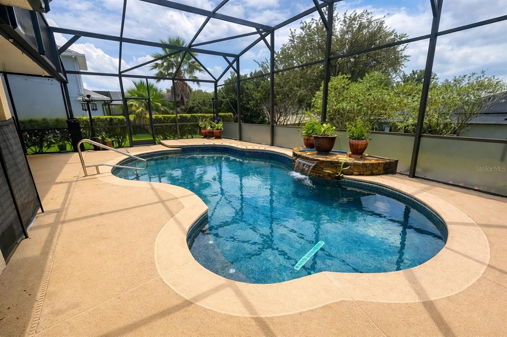 A kitchen features wood cabinets, granite countertops, stainless steel appliances, and wood-look tile flooring — 3814 THORNEWOOD WAY, CLERMONT, FL