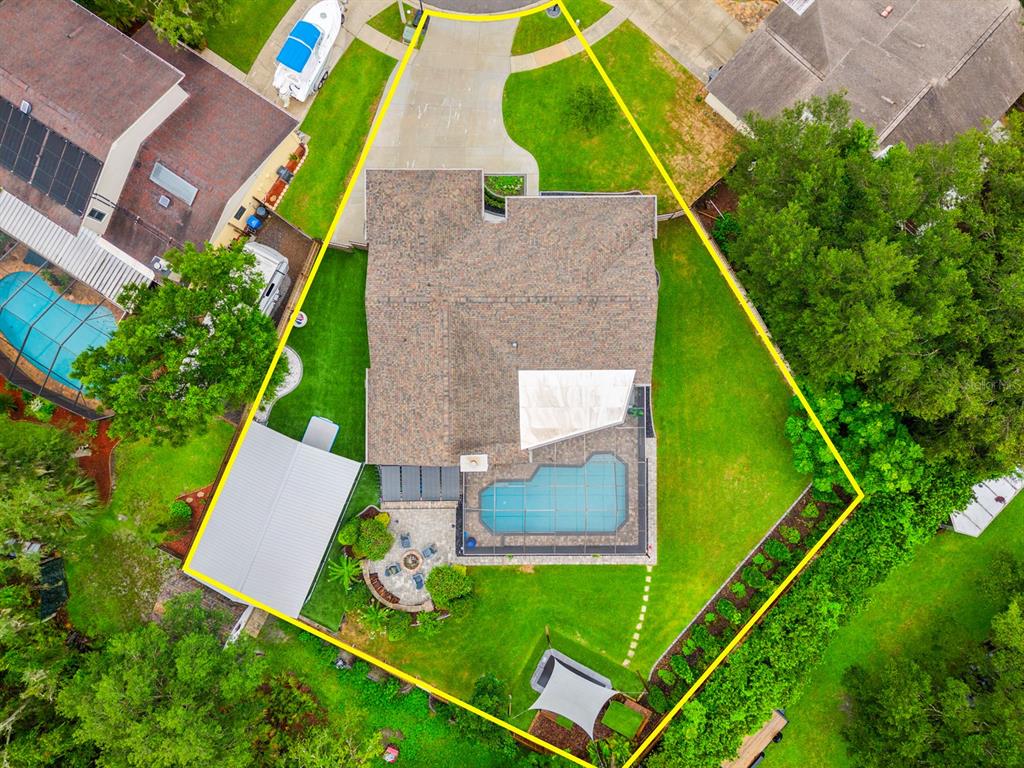 An aerial view shows a house with a pool, patio, and detached garage on a lot — 3906 BRAUN WAY, VALRICO, FL