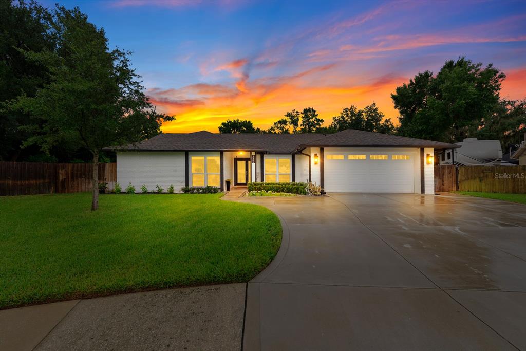 A single-story white brick house with a two-car garage and a curved concrete driveway — 3906 BRAUN WAY, VALRICO, FL
