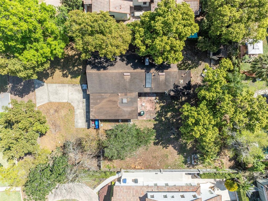 An aerial view shows a residential property outlined in yellow within a suburban neighborhood — 1560 LAKEHURST AVENUE, WINTER PARK, FL