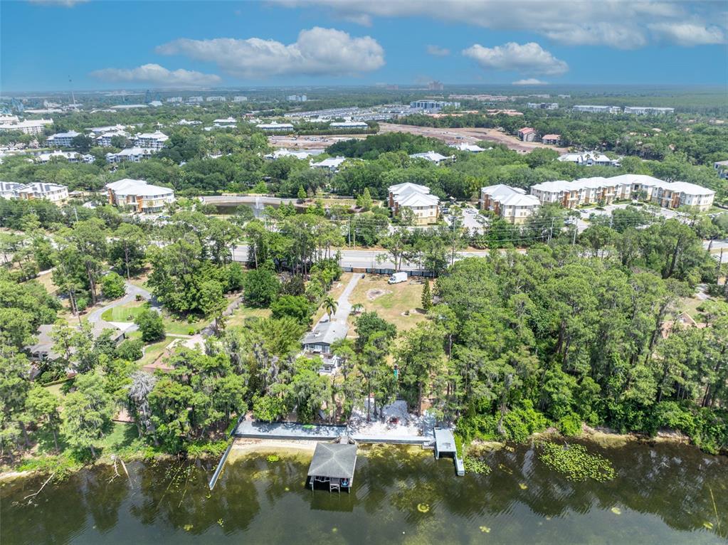 An aerial view shows a house with a private dock on a lake near woods — 11424 WESTWOOD BOULEVARD, ORLANDO, FL