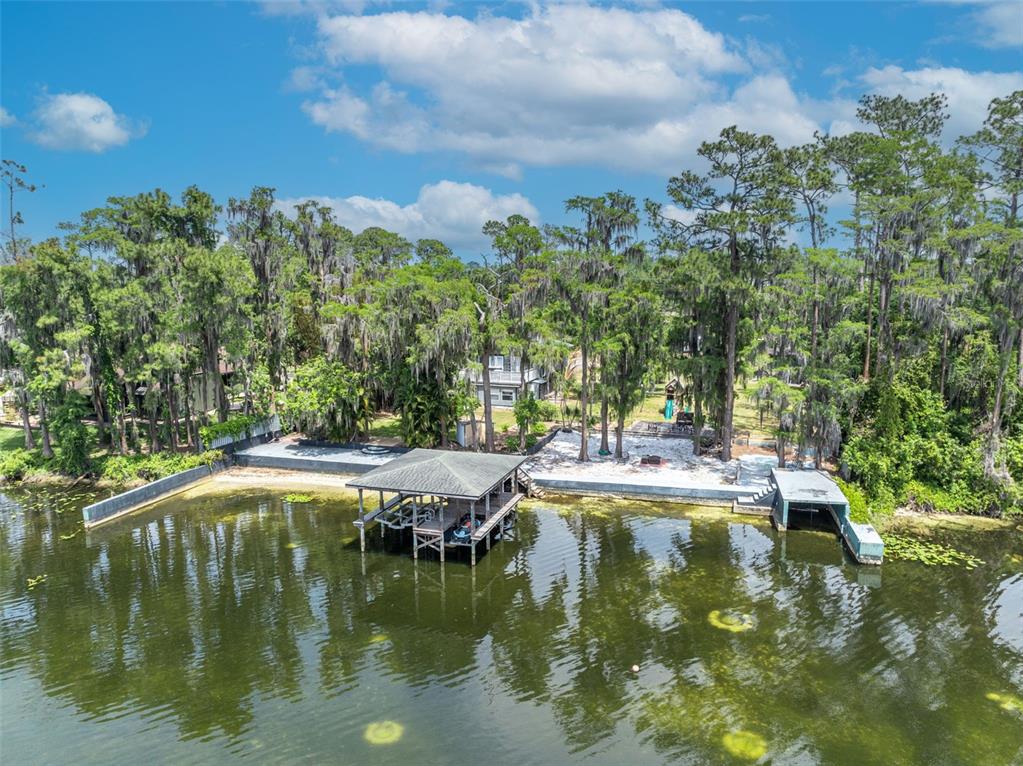 An aerial view of a lakefront property featuring a boat dock, boat house, and sandy beach — 11424 WESTWOOD BOULEVARD, ORLANDO, FL