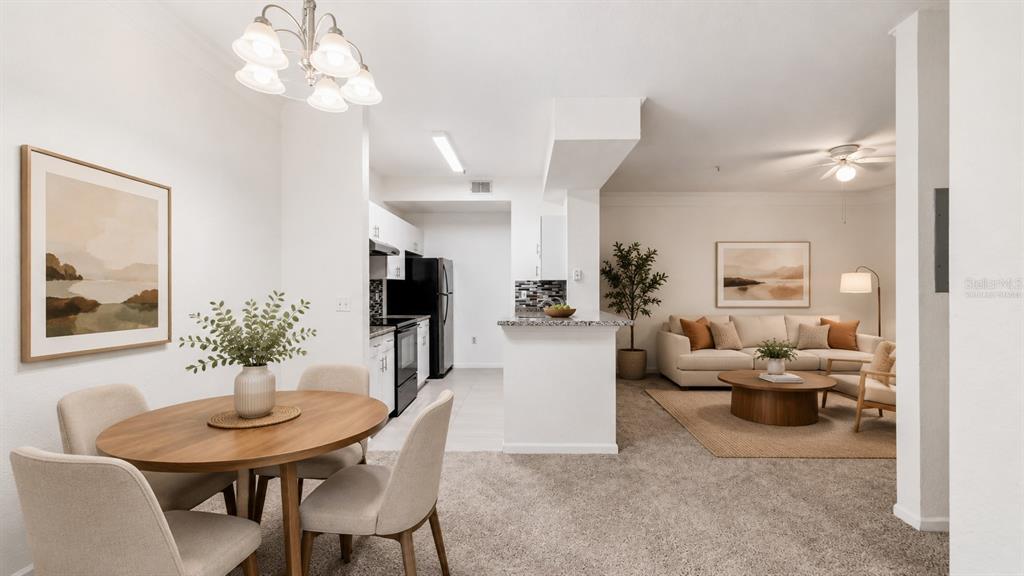 An open-concept living and dining area features neutral walls, carpeted floors, and a kitchen — 17112 CARRINGTON PARK DRIVE UNIT 926, TAMPA, FL