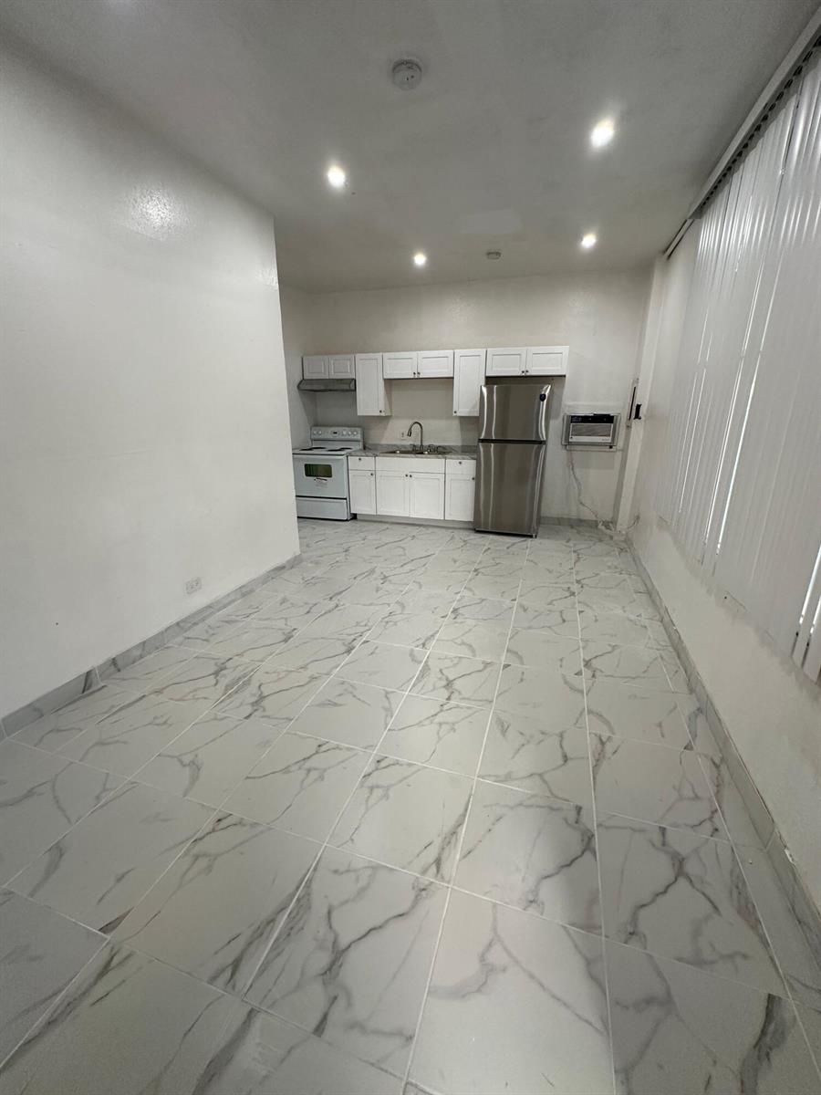 A kitchen with white cabinets, stainless steel appliances, and white marble-patterned tile flooring — 804 Orange Avenue # B, Fort Pierce FL 34950, FORT PIERCE, FL