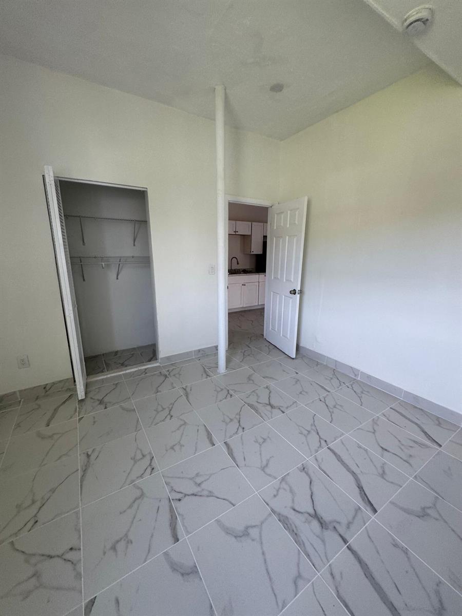 A room with white marble-patterned tile flooring, a closet, and a central support pole — 804 Orange Avenue # B, Fort Pierce FL 34950, FORT PIERCE, FL