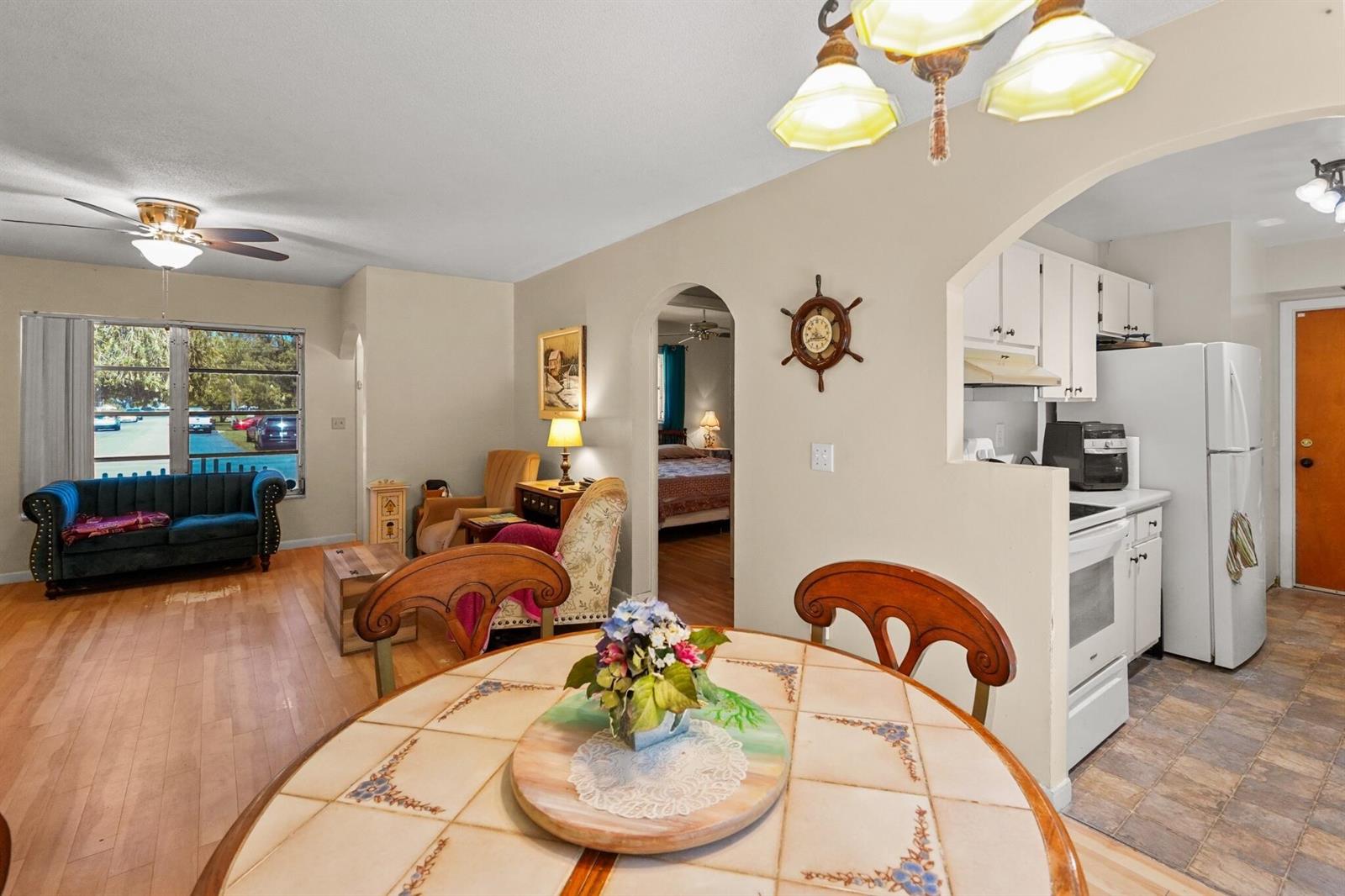 A dining area with a tiled table opens into a living room and kitchen — 1515 CRESCENT Drive, Lake Park FL 33403, LAKE PARK, FL