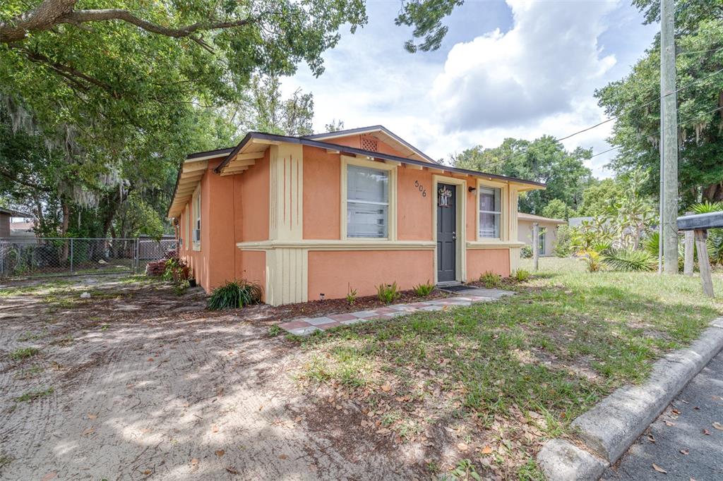 A single-story orange stucco house with yellow trim and a dark front door — 506 WHITEHURST STREET, LAKELAND, FL
