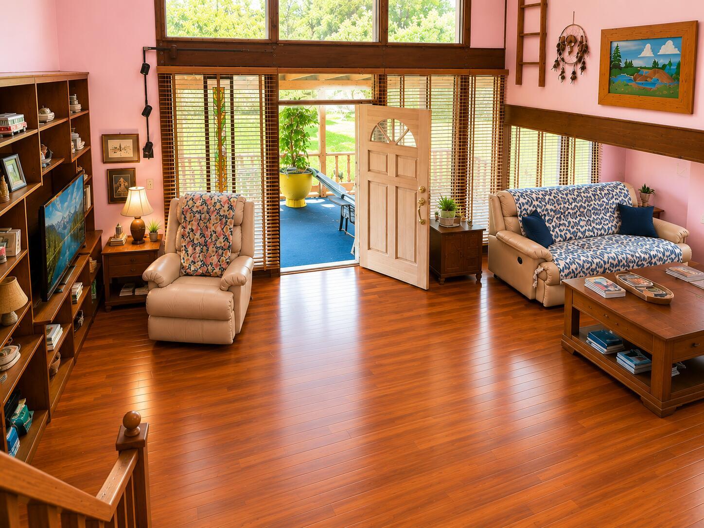 A living room with wood flooring, a beige recliner, a patterned sofa, and an open door — 123 Pine Lane, Clewiston FL 33440, CLEWISTON, FL