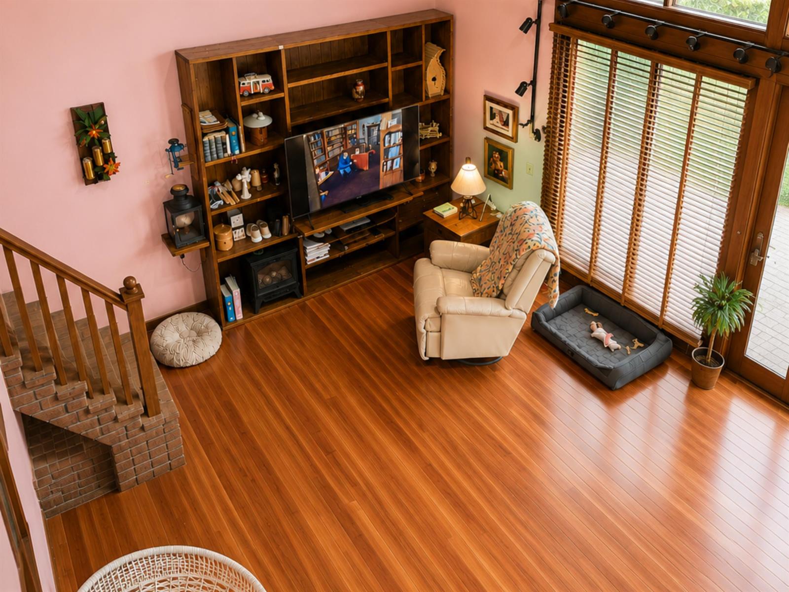 An elevated view of a living room featuring hardwood floors, a large bookshelf, and stairs — 123 Pine Lane, Clewiston FL 33440, CLEWISTON, FL