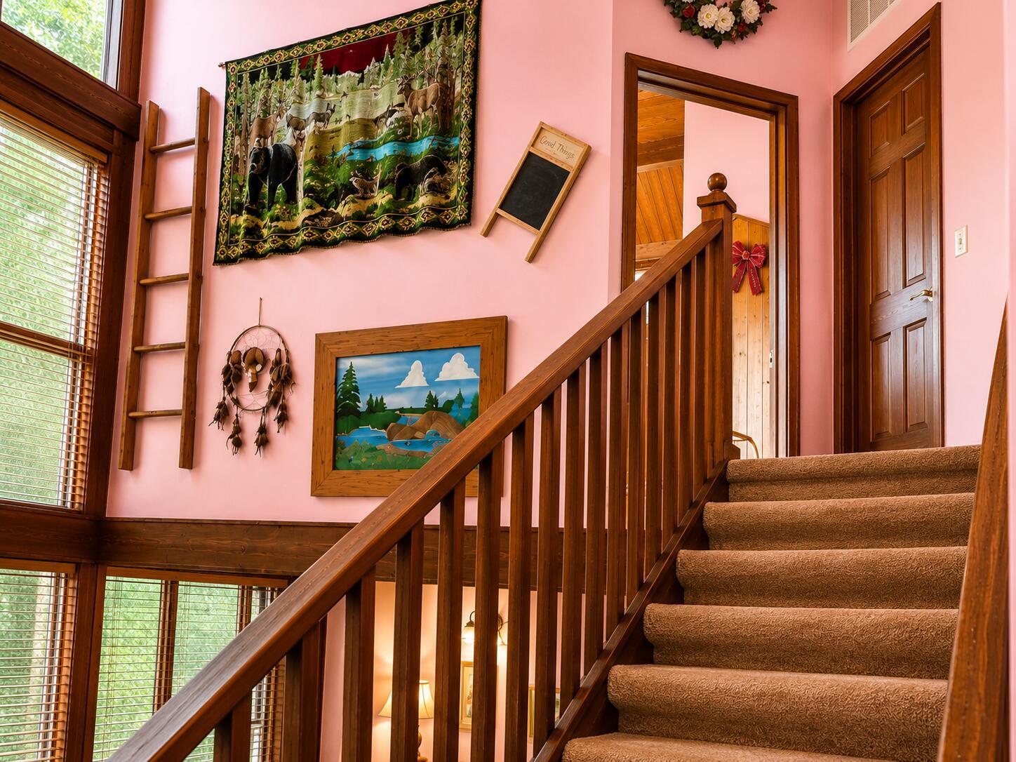 A carpeted staircase with a wooden railing leads up past pink walls with wall decor — 123 Pine Lane, Clewiston FL 33440, CLEWISTON, FL