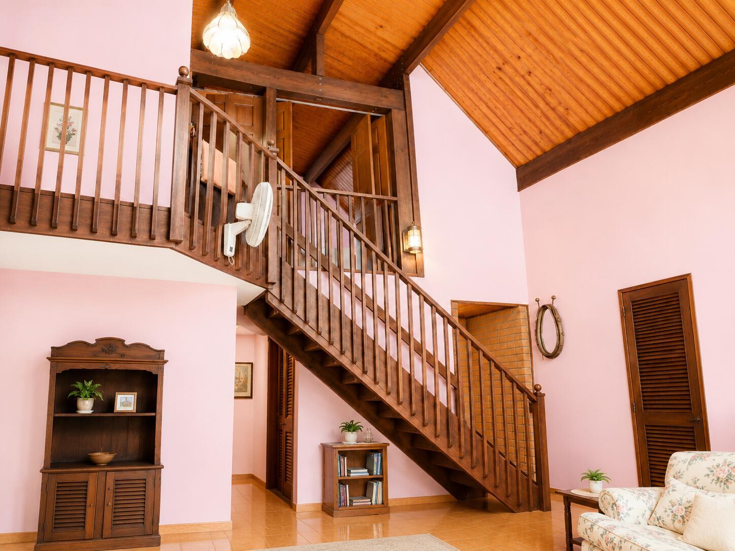 A living room with pink walls, a wooden staircase, and a vaulted wood-paneled ceiling — 123 Pine Lane, Clewiston FL 33440, CLEWISTON, FL