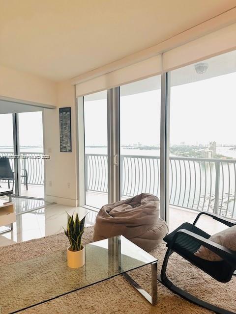 A living room features a glass coffee table, a beanbag chair, and floor-to-ceiling balcony windows — 1750 N Bayshore Dr # 2302, Miami FL 33132, MIAMI, FL