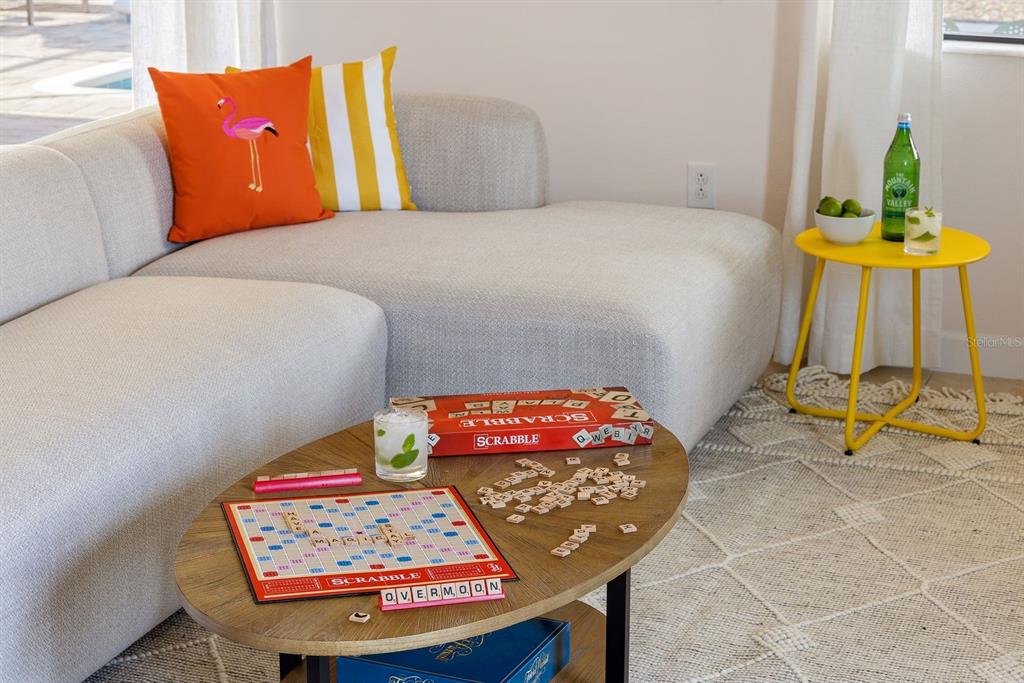 A living room features a light gray sectional sofa, a wooden coffee table with Scrabble, and a yellow side table — 9034 SHADOW MOUNTAIN STREET, DAVENPORT, FL
