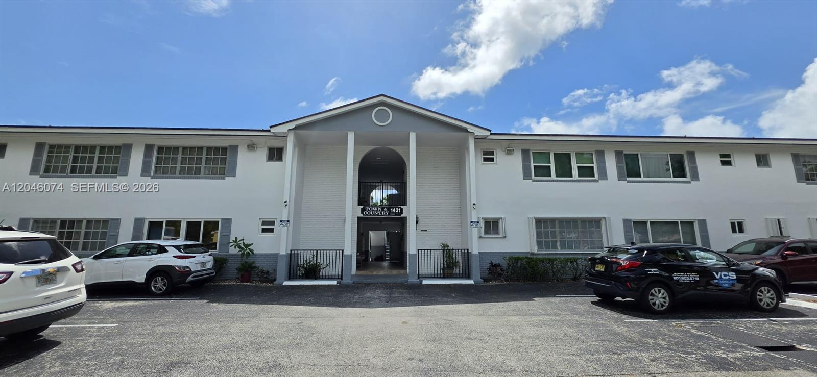 A two-story white apartment building with a central arched entrance and a parking lot — 1431 S 14th Ave # 217, Hollywood FL 33020, HOLLYWOOD, FL