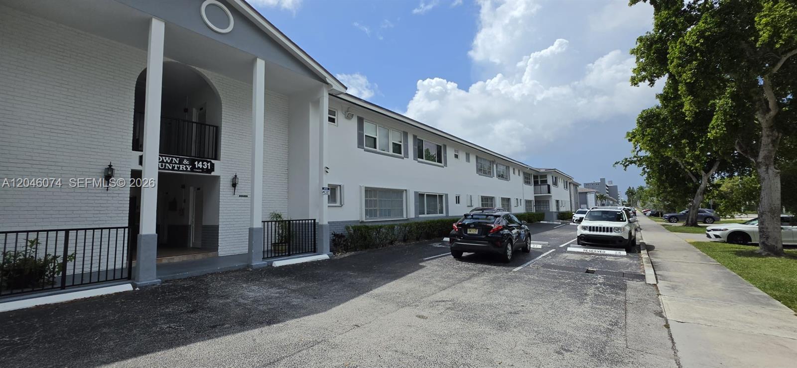 A two-story apartment building features a white brick facade and a paved parking lot — 1431 S 14th Ave # 217, Hollywood FL 33020, HOLLYWOOD, FL