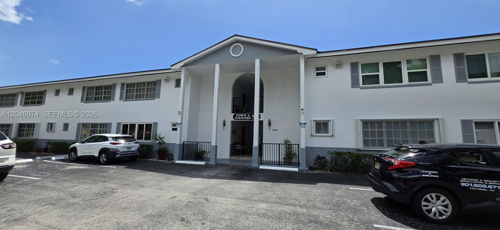 A two-story apartment building exterior features a central arched entryway and a paved parking lot — 1431 S 14th Ave # 217, Hollywood FL 33020, HOLLYWOOD, FL
