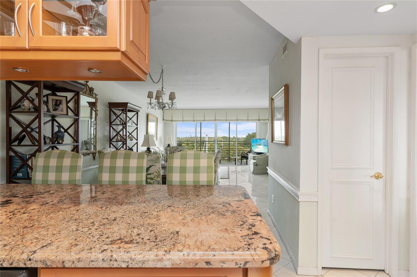 A kitchen counter with granite countertops overlooks a dining area and a bright living room — 2731 NE 14th Street Causeway # 637, Pompano Beach FL 33062, POMPANO BEACH, FL
