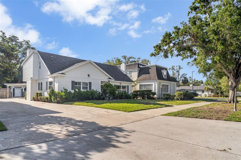 A white house with a dark shingled roof sits next to a driveway and lawn — 216 S SHORE CREST DRIVE, TAMPA, FL