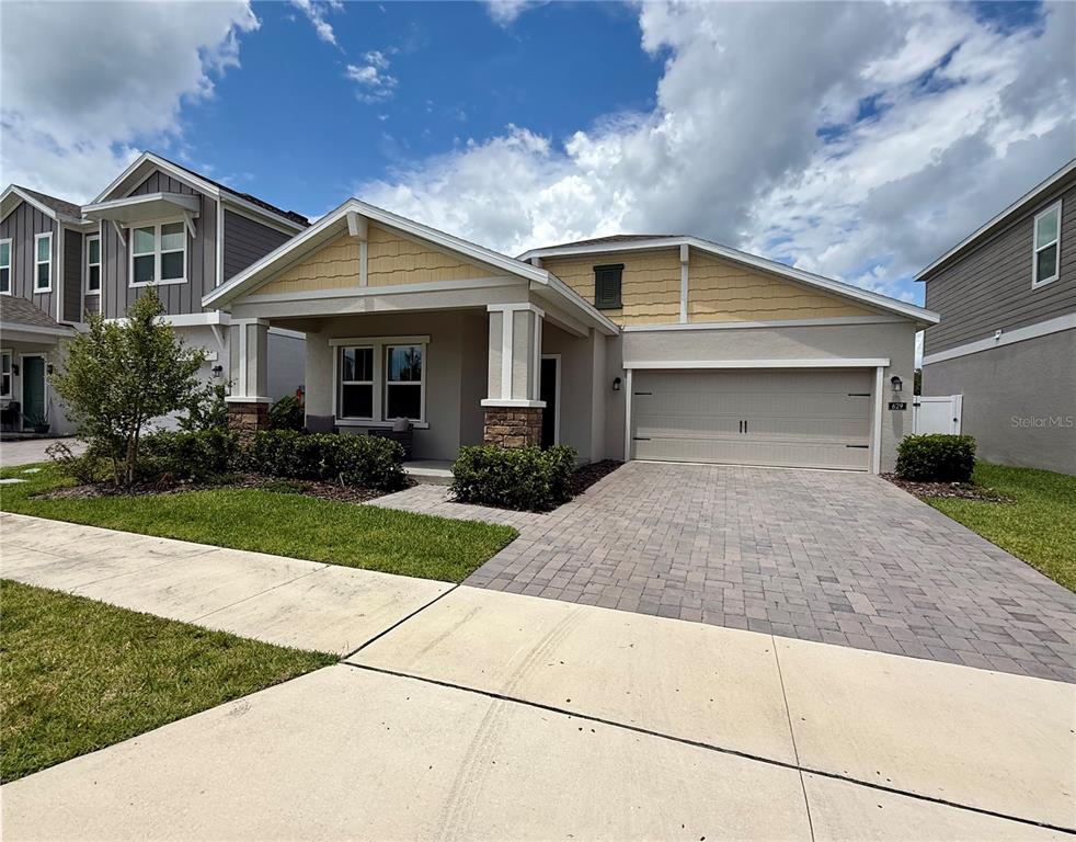 A single-story house with a beige stucco exterior, stone accents, and a paved driveway — 629 TERRAPIN DRIVE, DEBARY, FL