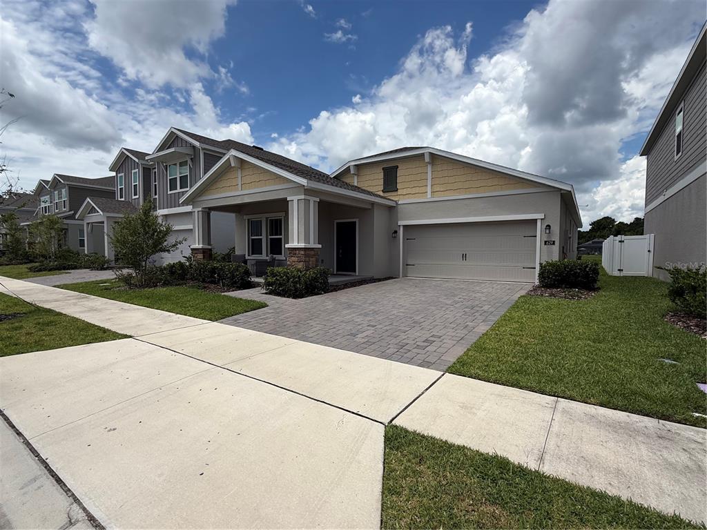 A single-story suburban house with a paved driveway, a covered porch, and yellow siding accents — 629 TERRAPIN DRIVE, DEBARY, FL
