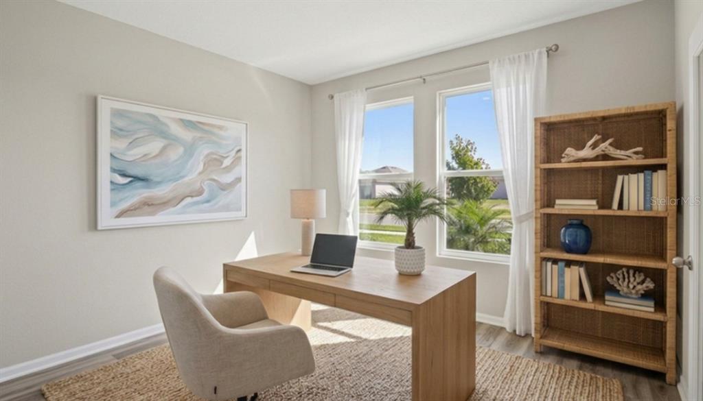 A home office features a wooden desk, an upholstered chair, and a woven bookshelf — 32744 WEATHERED OAK DRIVE, WESLEY CHAPEL, FL