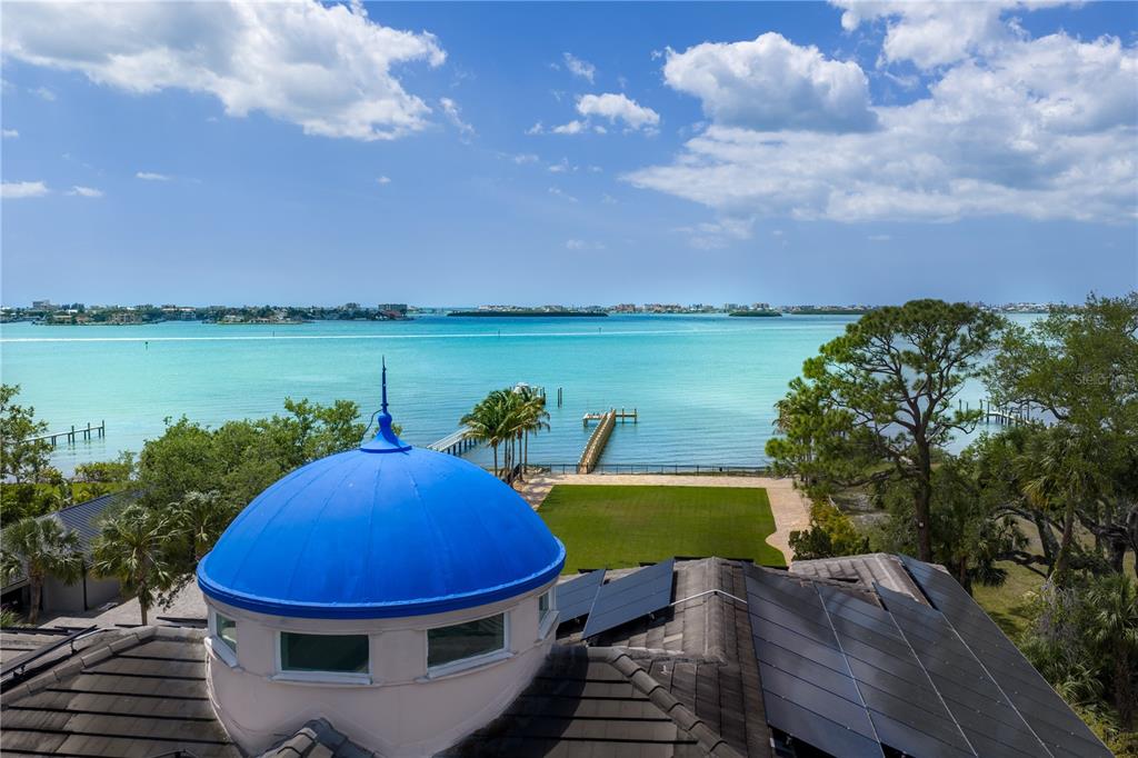 An aerial view shows a blue dome roof, solar panels, a lawn, and a waterfront dock — 2000 PARK STREET N, ST PETERSBURG, FL