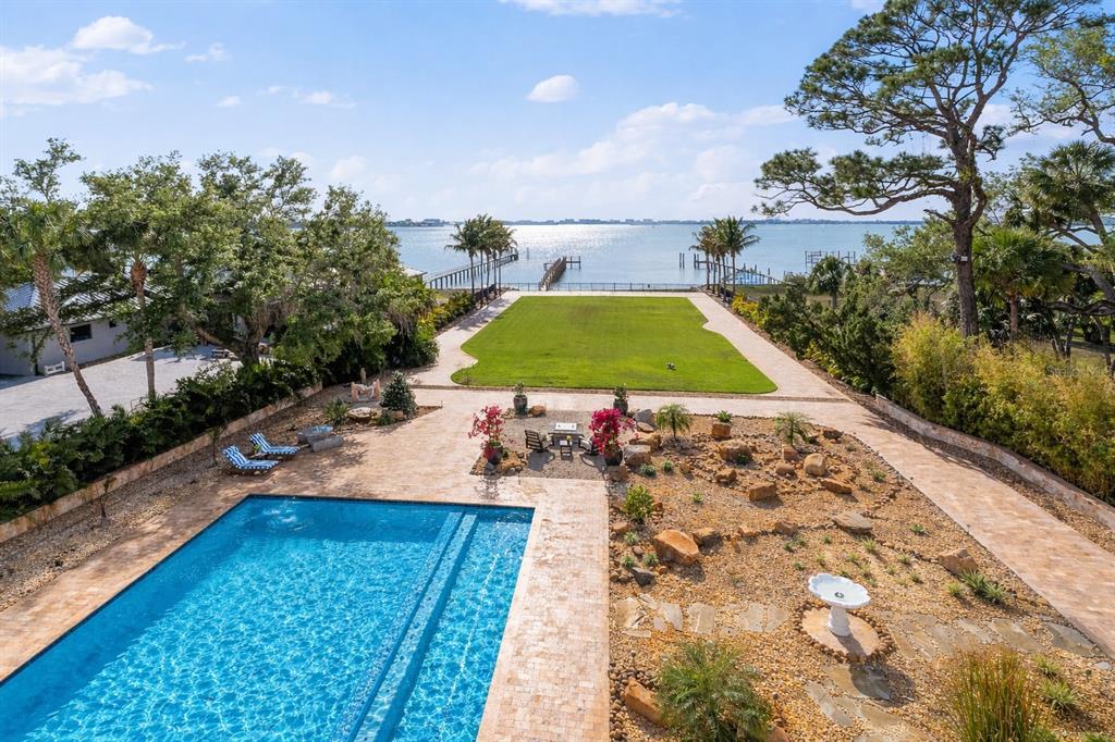 An aerial view of a backyard featuring a swimming pool, lawn, and a private dock — 2000 PARK STREET N, ST PETERSBURG, FL